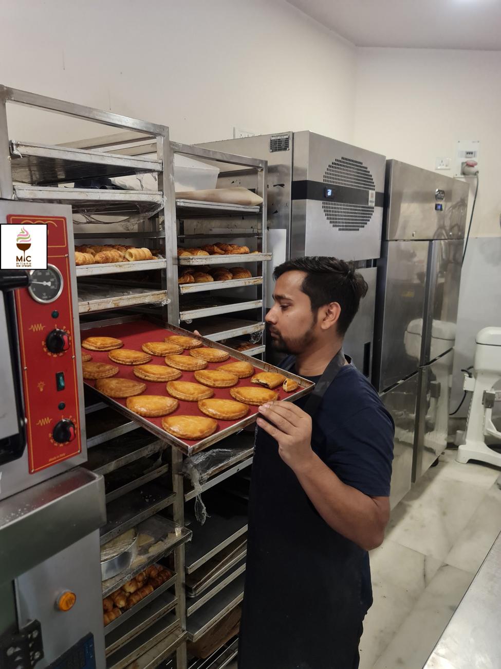 Baker pulling a tray of pastries at Milano